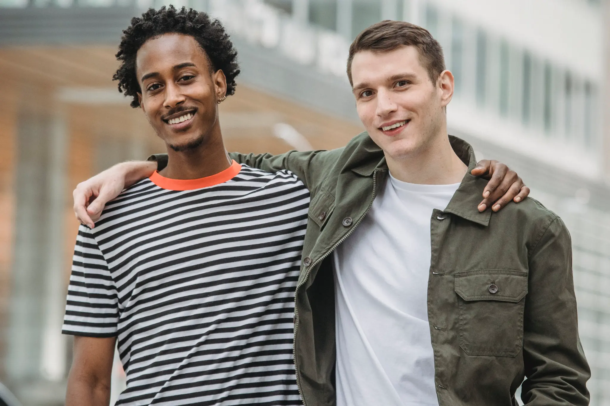 Two gay friends smiling together outdoors